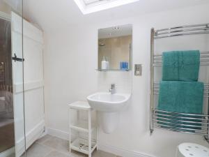 a white bathroom with a sink and a mirror at 19 Covert Road in Southwold +16 photos