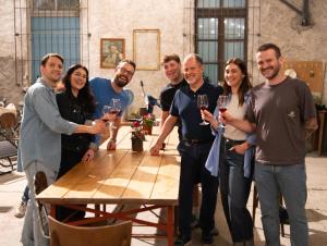 a group of people standing around a table holding wine glasses at Dimora Perla di Villa - Spacious Wine Estate Retreat near Bernina Express in Villa di Tirano