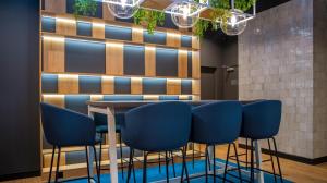 a bar with blue chairs and a table at B&B HOTEL Kielce Centrum in Kielce