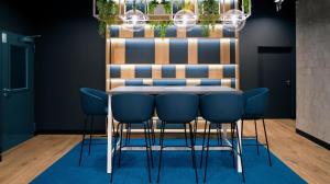 a dining room with a table and blue chairs at B&B HOTEL Kielce Centrum in Kielce