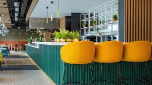 a row of yellow chairs in a restaurant at B&B HOTEL Kielce Centrum in Kielce +38 photos
