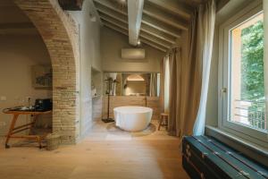 a bathroom with a tub in the middle of a room at Palazzo Lucchini in Montalcino