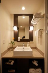ein Badezimmer mit einem Waschbecken und einem großen Spiegel in der Unterkunft Agora Place Osaka Namba in Osaka