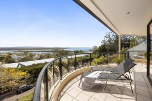 a balcony with two chairs and a view of the ocean at Penthouse with Incredible Views & Pool in Noosa Heads