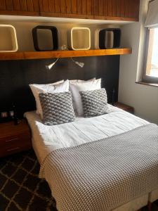 a bedroom with a bed with two mirrors above it at Tania nice chalettt garden view in Courchevel