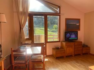 a living room with a television and a window at Tania nice chalettt garden view in Courchevel