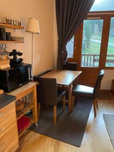 a dining room with a table and a microwave at Tania nice chalettt garden view in Courchevel