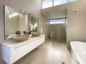 a bathroom with two sinks and a mirror and a shower at Stunning Views, Private Pool Near Hastings St in Noosa Heads