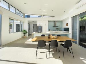 a kitchen and dining room with a wooden table and chairs at Stunning Views, Private Pool Near Hastings St in Noosa Heads