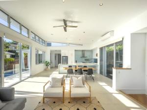 a living room with a ceiling fan and a table and chairs at Stunning Views, Private Pool Near Hastings St in Noosa Heads +41 photos