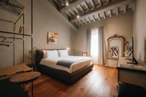 a bedroom with a bed and a table and a mirror at Palazzo Lucchini in Montalcino