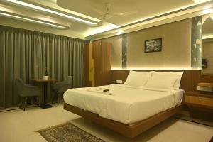 a bedroom with a bed and a table and chairs at Hotel High Rise in Kolkata