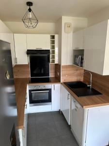 a kitchen with a sink and a stove top oven at Modern 2BR Train, Versailles, Paris in Plaisir