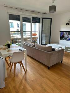 a living room with a couch and a table at Modern 2BR Train, Versailles, Paris in Plaisir
