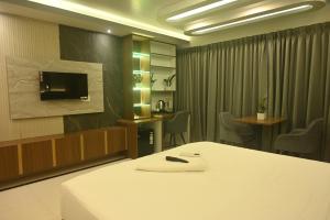 a hotel room with a bed and a tv at Hotel High Rise in Kolkata