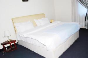 a large white bed in a hotel room at KAA Highway Hotel in Mukono