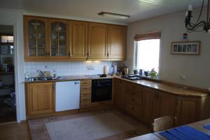 a kitchen with wooden cabinets and a white dishwasher at Engeset Villa in Volda