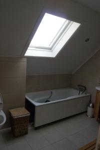 a bath tub in a bathroom with a skylight at Engeset Villa in Volda +16 photos