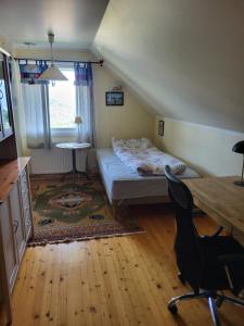 a bedroom with a bed and a desk and a chair at Engeset Villa in Volda