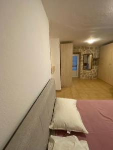 a bed in a room with a wall at Stoun house in Reževići