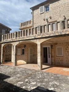 a stone house with an archway in front of it at Stoun house in Reževići