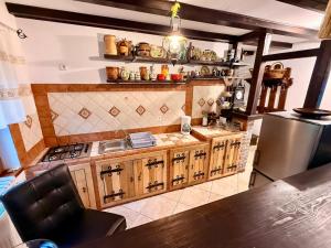 a kitchen with wooden cabinets and a stainless steel refrigerator at Forest Chalet Sucevita in Suceviţa