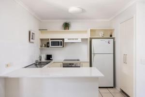 a kitchen with a white counter top and a refrigerator at Riverside Rest on Noosa River in Noosaville