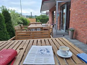 a table with a cup of coffee and a book on it at Gościniec Celina in Krasnobród