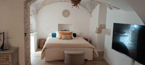 a bedroom with a bed and a flat screen tv at Torre del Fornello in Putignano