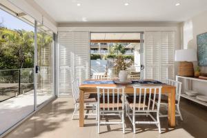 a dining room with a wooden table and chairs at Townhouse with Private Magnesium Pool in Noosa Heads