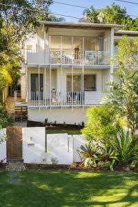 a white house with a white fence in front of it at Townhouse with Private Magnesium Pool in Noosa Heads