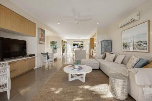 a living room with a couch and a table at Townhouse with Private Magnesium Pool in Noosa Heads