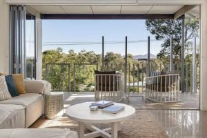 a living room with a couch and two chairs at Townhouse with Private Magnesium Pool in Noosa Heads +15 photos