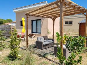 a patio with a couch under a wooden pergola at Gite avec piscine in Crespian