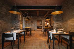 a restaurant with tables and chairs in a stone wall at Palazzo Lucchini in Montalcino +42 photos
