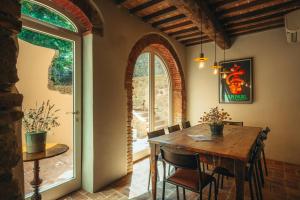 a dining room with a wooden table and a window at Palazzo Lucchini in Montalcino