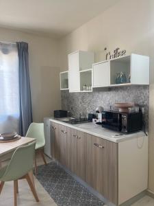a kitchen with white cabinets and a microwave at La casetta in Teulada