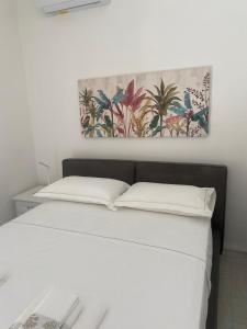 a bedroom with a bed with a painting on the wall at Dietro La Torre in Lizzano