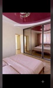 a bedroom with a large bed with a large mirror at Bright House in Bila Tserkva