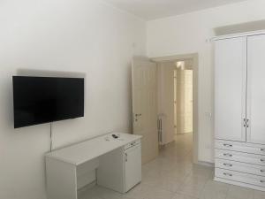 a white room with a flat screen tv on a wall at Dietro La Torre in Lizzano