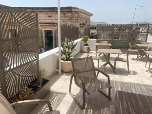 a patio with chairs and tables on a roof at Dietro La Torre in Lizzano