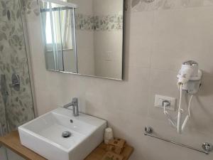 a bathroom with a sink and a hair dryer on the wall at Dietro La Torre in Lizzano +14 photos
