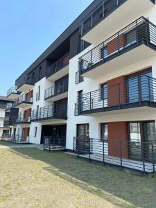 an apartment building with balconies and a yard at Apartament przy Matce Polce in Łódź