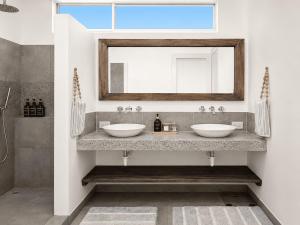 a bathroom with two sinks and a mirror at Sandy Feet House in Puerto Villamil