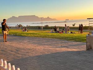 a man standing in a park near the beach at The Cabernet Cottage - One Bedroom in Table View +11 photos