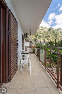 a balcony with a table and chairs and mountains at Bonaca Apartments in Kotor