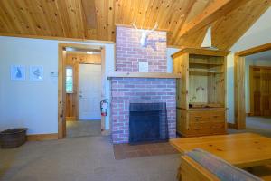 a brick fireplace in a room with a wooden ceiling at 148 Divot Simcoe Cottage private Beach, Kayak in Georgina