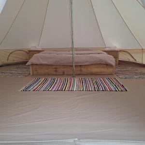a bed in a tent with a rug at CampingSiriu in Caşoca