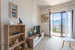 a living room with a television and a balcony at Bonaca Apartments in Kotor