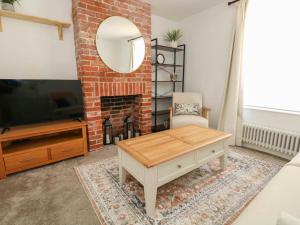 a living room with a brick fireplace and a coffee table at The Watch House in Weymouth